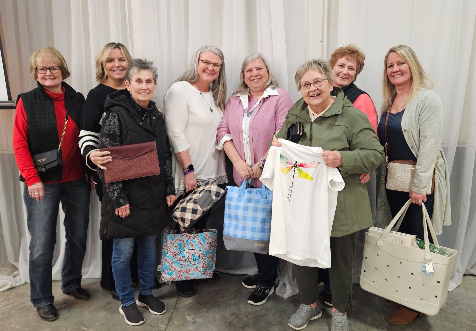 A group of women showing off their winnings from 2025 bingo.