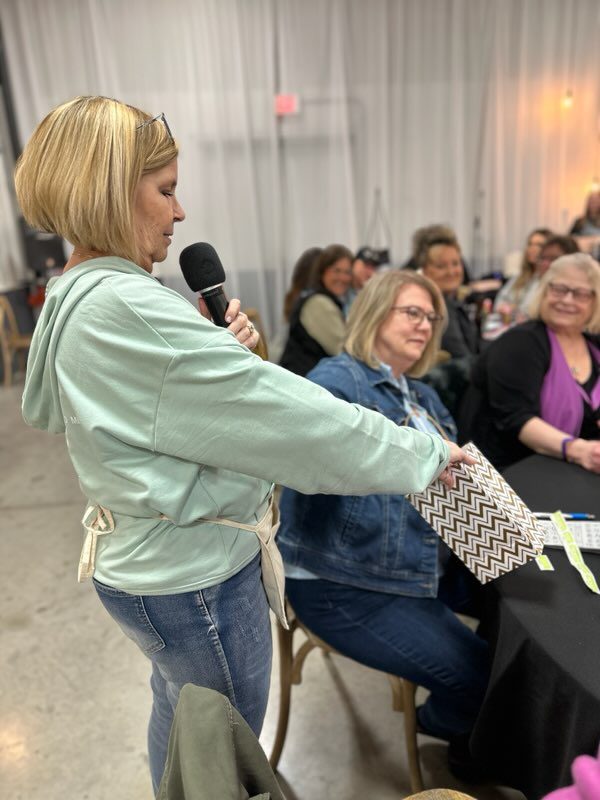 DMWF President, LuAnn McFarlane, draws a name for our mystery prize at bingo 2025.